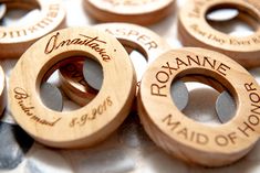 several wooden wedding rings with names on them