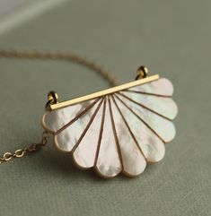 This beautiful Art Deco pendant necklace is pure Mother of Pearl which has been carved into a simple scalloped semi-circle shape.  The pearl has an incredible sheen and take on a subtle glow when they catch the light.  The pendant is finished with a delicate and fine gold plated chain.   This necklace is available in a choice of chain lengths.  Please refer to our illustrated guide for a better idea of how they might look when worn.   🖤 FASTER SHIPPING 🖤 Need this fast? We offer a Faster Shipp White Shell Necklace, Art Deco Pendant Necklace, Pearl Drop Necklace, Art Deco Pendant, Art Deco Necklace, Shell Necklace, Circle Necklace, Bridal Pearls, Circle Shape