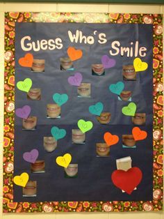 a bulletin board that says guess who's smile with hearts and flowers on it