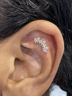 a close up of a person's ear with two small flowers on the side