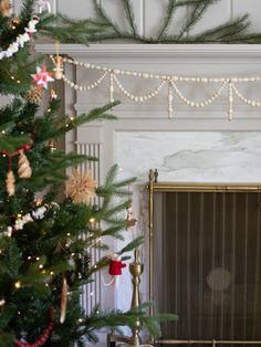 a decorated christmas tree in front of a fireplace