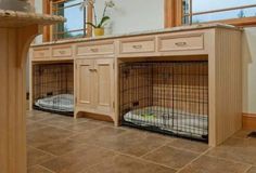 two wooden dog kennels with their doors open on the floor next to each other