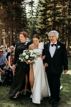 the bride and groom are walking down the aisle with their mother, who is holding her bouquet