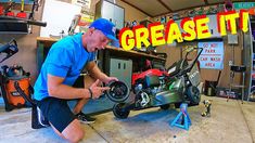 a man working on a motorcycle in a garage with the words grease it above him