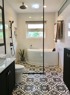 a bathroom with a black and white tile floor, tub, sink and shower stall