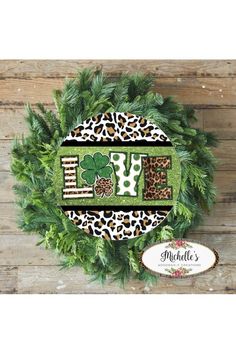 a green wreath with leopard print and the word love on it next to a sign