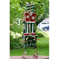 a stack of christmas gifts sitting on top of a wooden table