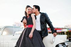 a man standing next to a woman near a car