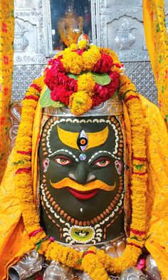 a mask with flowers on it sitting in front of a door and some other decorations