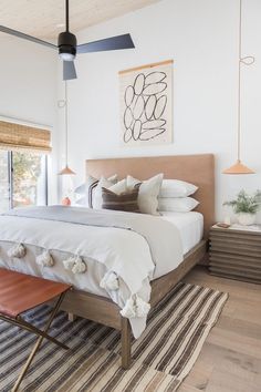 a bedroom with a bed, rugs and ceiling fan in the middle of it