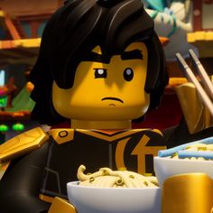 the lego movie character is eating noodles with chopsticks