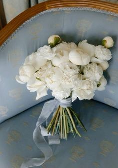 a bouquet of white flowers sitting on top of a blue chair