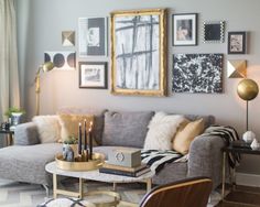 a living room filled with furniture and pictures hanging on the wall above it's coffee table