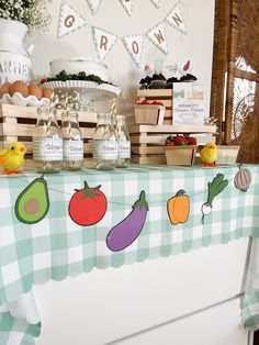 a table topped with lots of food on top of a white counter covered in green and white checkered cloth