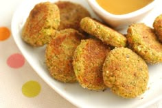 some fried food on a white plate with dipping sauce