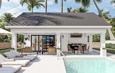 a pool house with an outdoor dining area next to it and palm trees in the background