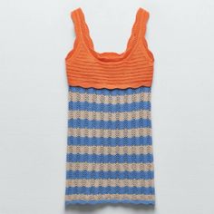 an orange and blue striped tank top on a white surface with the bottom half turned down