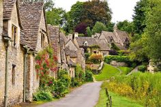 an old village with stone buildings and green grass