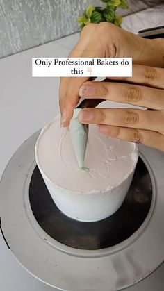 a woman is decorating a cake with white frosting