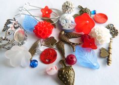 there are many different types of buttons on this white tablecloth, including brooches and earrings