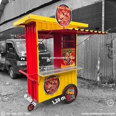 a yellow and red food cart sitting in front of a building