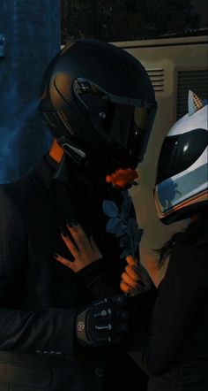 a man in a suit and helmet is talking to a woman with her hand on his chest