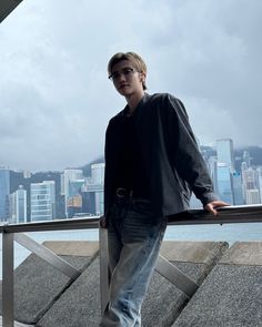 a man standing on top of a metal railing