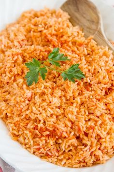 a white bowl filled with rice and topped with cilantro on a colorful napkin