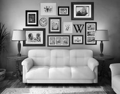 black and white photograph of a living room with couches, lamps and pictures on the wall