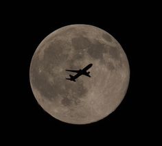 an airplane is flying in front of the moon