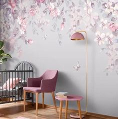 a baby's room with pink furniture and flowers painted on the wall behind it