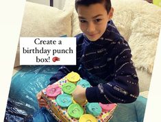 a young boy holding a birthday punch box