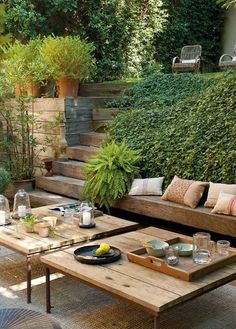 an outdoor living area with couches, tables and plants