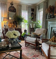 a living room filled with lots of furniture and flowers on top of a coffee table