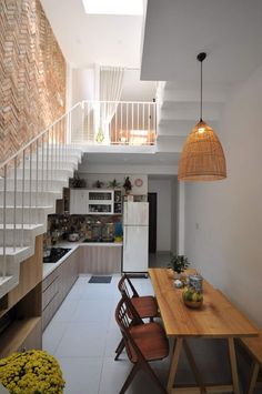 a kitchen and dining area with stairs leading up to the second floor