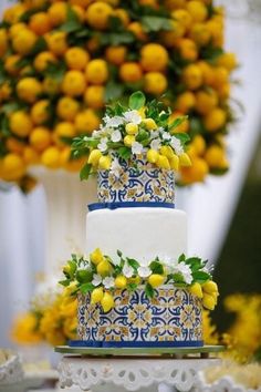 a three tiered cake with yellow and white flowers