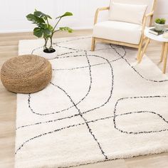 a living room area with a chair, rug and potted plant