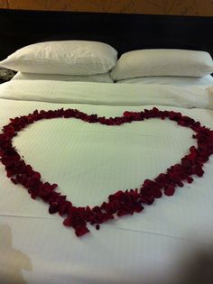 a heart shaped bed with petals on it