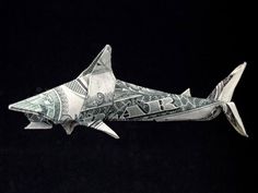 a dollar bill origami shark on a black background