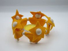 a close up of a candle holder made out of orange and white fabric with stars on it