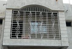 a clock on the side of a building next to a window with bars in it