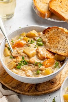 a bowl of chicken and vegetable soup with two slices of bread