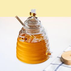 a honey jar and wooden spoon sitting on a table