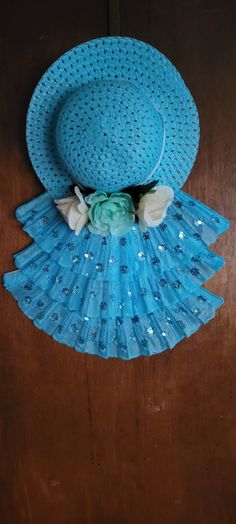 a blue hat with flowers on it sitting on top of a wooden table