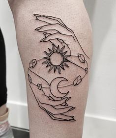 a tattoo on the leg of a woman with hands holding a sun and moon in it