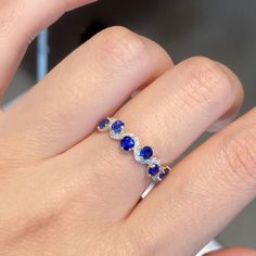 a woman's hand with a diamond and blue sapphire ring