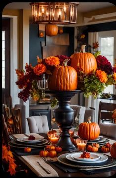 a dining room table decorated with pumpkins and candles