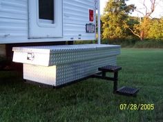 the back end of a trailer parked on grass