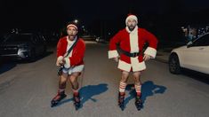 two men dressed as santa clause riding roller skates