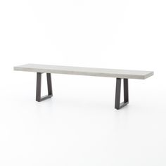 a white bench sitting on top of a white floor next to a black metal frame